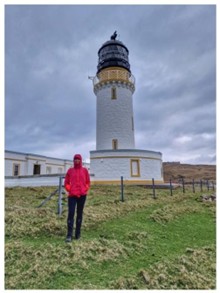 Cape Wrath lighthouse with Rachel at the end of her trek.
